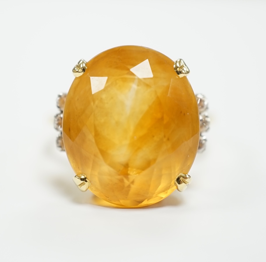 An 18k and single stone oval cut citrine set dress ring, with six stone diamond set shoulders, size R, gross weight 8.3 grams.
